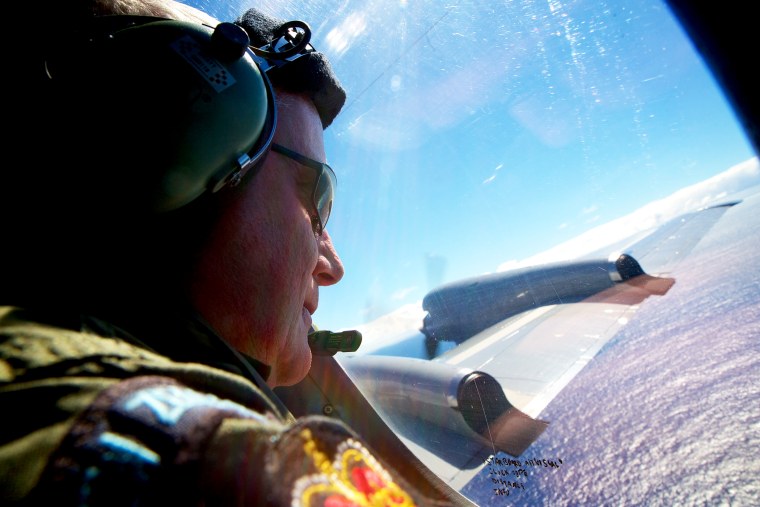 Sergeant Trent Wyatt looks out an observation window aboard a Royal New Zealand Air Force search aircraft as it flies over the southern Indian Ocean looking for debris from missing Malaysian Airlines flight MH370, April 11, 2014.