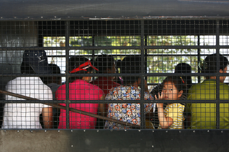 A young girl looks out as group of asylum seekers depart for a courthouse from the Chiang Saen police station in Thailand's Chiang Rai province.