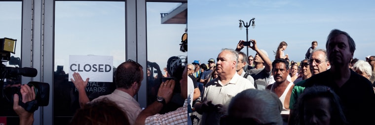 (right) A security guard sticks a closed sign to the front door of the Showboat Atlantic City Hotel and Casino as (left) onlookers watch the final day of gaming before shutting down operations at the casino on Aug. 31, 2014.