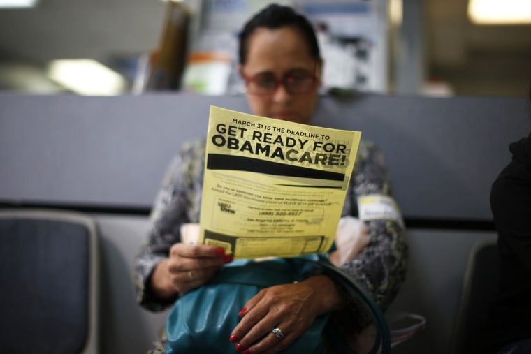 A woman reads a leaflet at a health insurance enrollment event in Cudahy, Calif., March 27, 2014