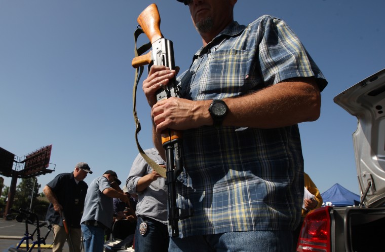 Police officers remove surrendered guns from the trunks of cars at a gun buyback on May 31, 2014 in Los Angeles, Calif.