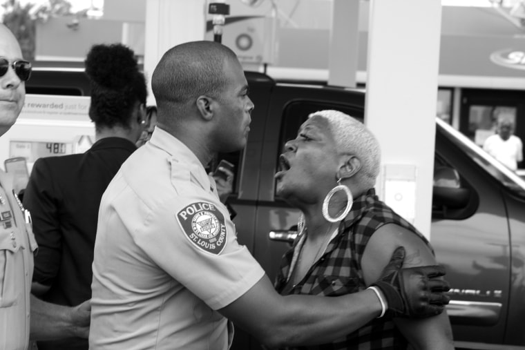 A protestor shouts at an officer after police ran into the crowd, tackling and arresting a man in near Ferguson, Mo. on Sept. 10, 2014. The woman said the officers chased down the wrong person.