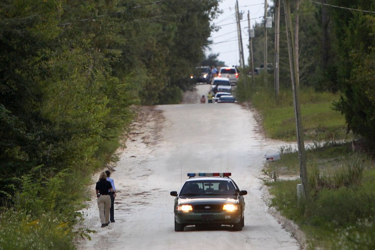 Officials walk along NW 29th Terrace near the scene of a shooting on  Sept. 18, 2014 in Bell, Fla.