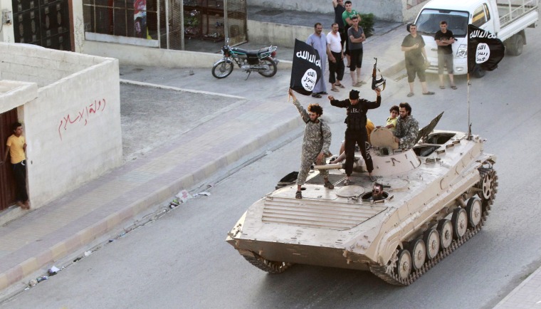 Militant Islamist fighters take part in a military parade along the streets of northern Raqqa province June 30, 2014.