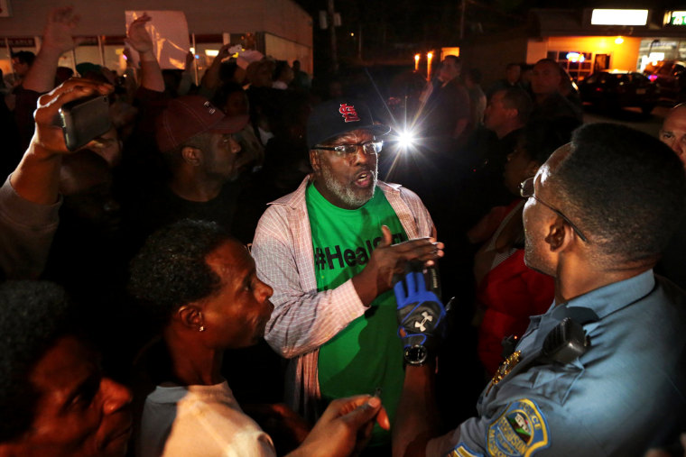 Protesters argue with a Ferguson sergeant who was trying to get them to disperse the area on West Florissant Avenue in Ferguson late Tuesday, Sept. 23, 2014.