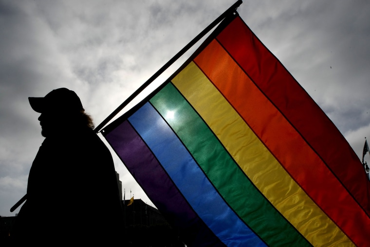 A man holds a gay pride flag. (Photo by Justin Sullivan/Getty)