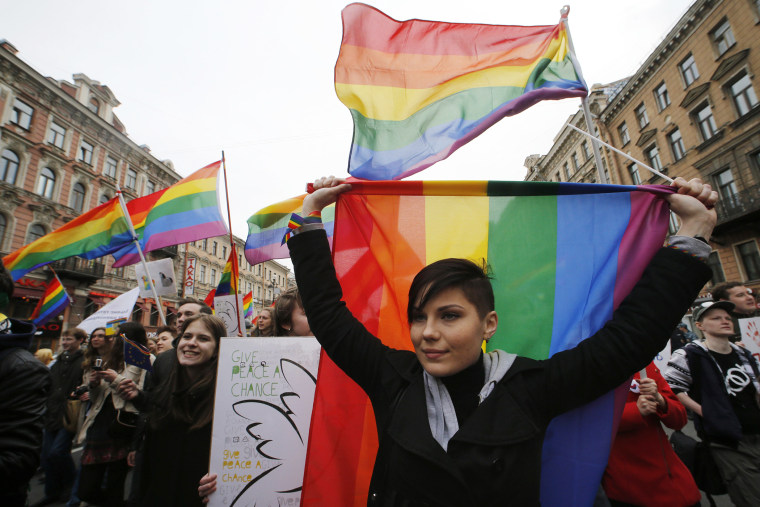 Gay rights activists march with flags and placards during a May Day rally in St. Petersburg
