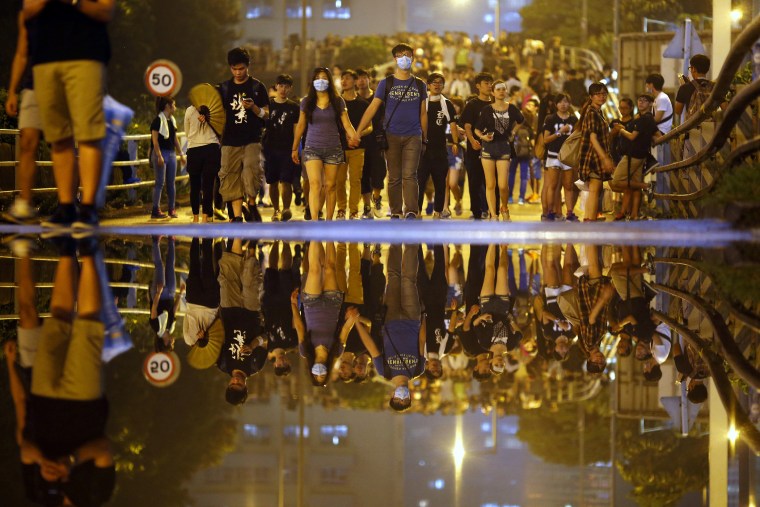 Protesters walk along a street as they block an area near the government headquarters building in Hong Kong