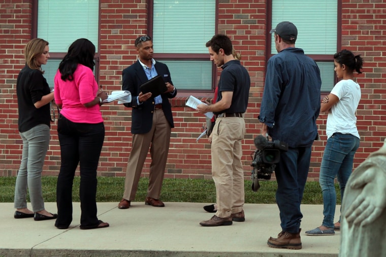 Devin James, a public relations spokesman for the City of Ferguson (third from left) briefs members of the media gathered for a town hall style meeting at Our Lady of Guadalupe Catholic Church on Sept. 22, 2014.