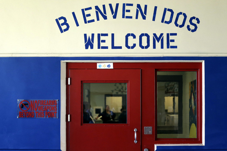 A Spanish and English welcome sign is seen above a door in a secured entrance area at the Karnes County Residential Center in Karnes City, Texas on July 31, 2014.