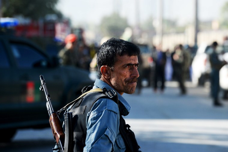 An Afghan policeman keeps watch at the site of a suicide attack in Kabul on October 2, 2014.