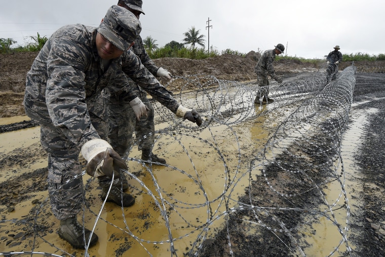 US Air Force soldiers place barbed wire in an area designated for a Ebola treatment center in Monrovia, on Oct. 6, 2014