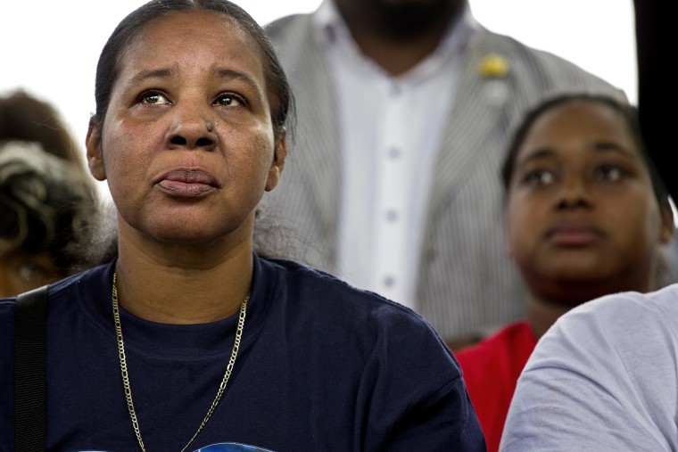 Esaw Garner, left, listens during remarks at a rally to protest the death of her husband Eric Garner, on Aug. 23, 2014, in the Staten Island borough of New York.