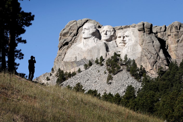 A tourist takes a picture of Mount Rushmore National Memorial from outside the park on Oct. 1, 2013 in Keystone, South Dakota.