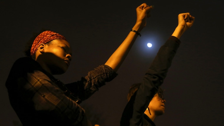 Demonstrators raise their hands during a moment of silence on the campus of Saint Louis University in St. Louis, Missouri early October 13, 2014. (Shannon Stapleton/Reuters)