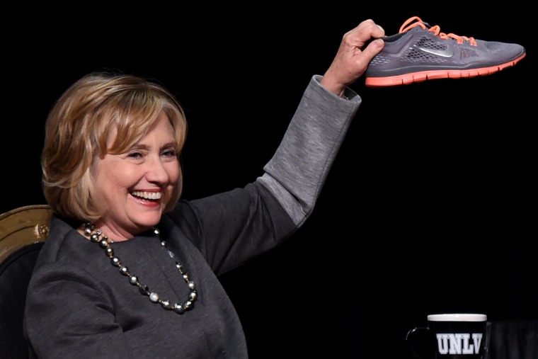Former U.S. Secretary of State Hillary Clinton holds up a running shoe she received as a gift at a fundraising dinner for the UNLV Foundation at the Bellagio on Oct. 13, 2014 in Las Vegas.