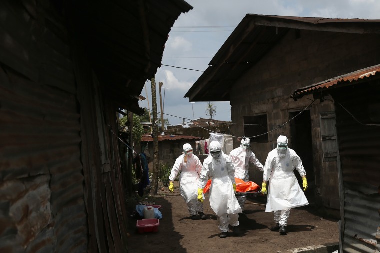 Ebola burial team members remove the body of Mekie Nagbe, 28, for cremation on Oct. 10, 2014 in Monrovia, Liberia.