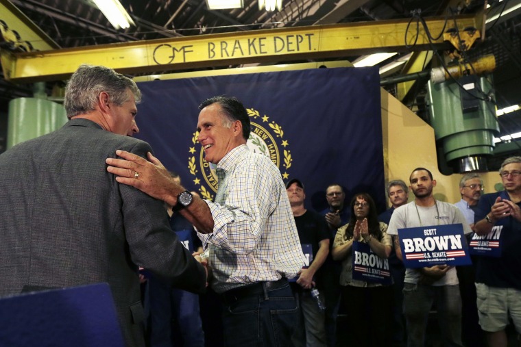 Former Republican Presidential candidate Mitt Romney gives New Hampshire Republican Senate candidate Scott Brown, left, a pat on the back during a campaign stop in Hudson, N.H. on Oct. 15, 2014.