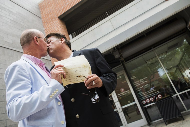 David Chaney, 50, (L) and Clark Rowley, 48, show off their marriage license and celebrate with a kiss after gay marriage was legalized in Phoenix, Arizona on Oct. 17, 2014