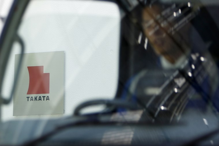 Logo of Takata Corp is seen through a car window outside the company's headquarter building in Tokyo