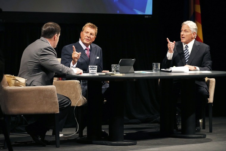 Republican Doug Ducey, left, and Democrat Fred DuVal, right, with moderator John Hook during a gubernatorial debate on Sept. 28, 2014, in Phoenix, Ariz.