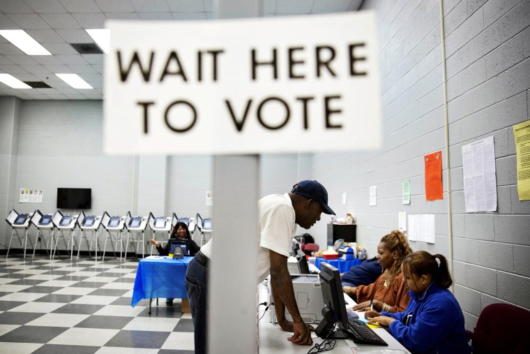Charles Poole, 70, checks in upon arriving to cast his ballot at a polling site during early voting in Atlanta, Ga. on May 16, 2014.