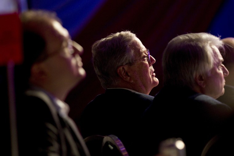 David Koch listens to Mitt Romney speak in Washington on Nov. 4, 2011.
