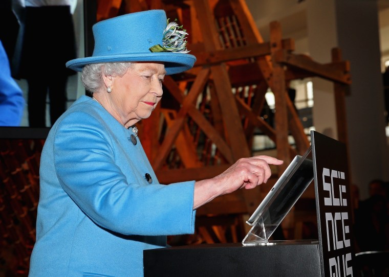 Britain's Queen Elizabeth II sends her first tweet during a visit to open the 'Information Age' exhibition at the Science Museum in London on Oct. 24, 2014.