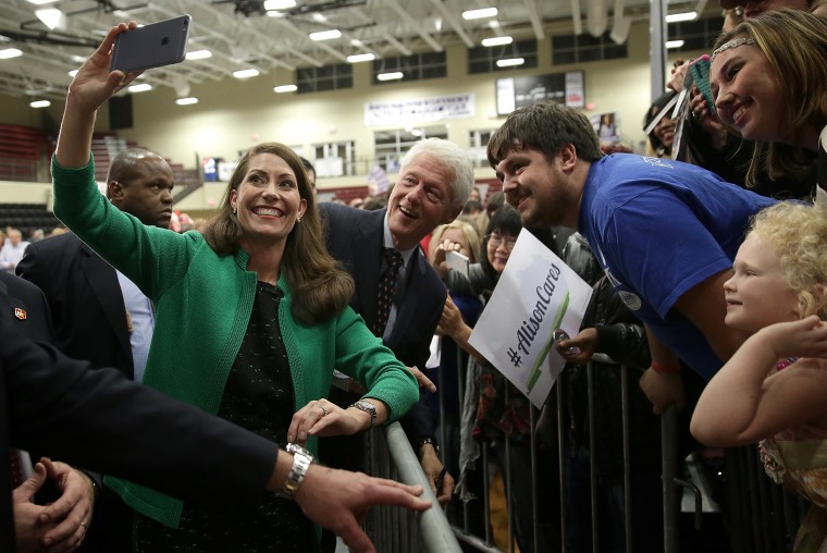 Former U.S. President Bill Clinton (C) and U.S. Senate Democratic candidate and Kentucky Secretary of State Alison Lundergan Grimes (L) take a \"selfie\" with Kentucky voters after they spoke at a rally Oct. 21, 2014 in Paducah, Ky.