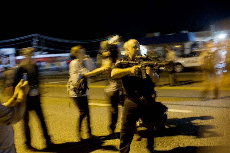 St. Ann, Missouri police officer Lt. Ray Albers points an assault rifle during a protest of the death of teenager Michael Brown on Aug. 19, 2014 in Ferguson, Mo.
