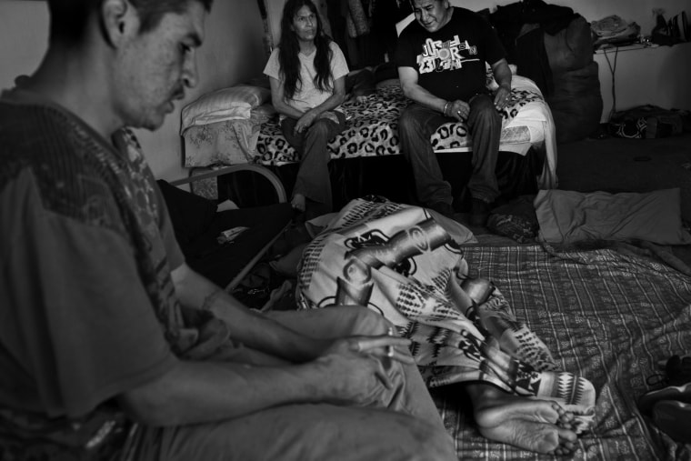 The Running Shield family sit together and watch TV inside the motel room they share in Rapid City, South Dakota.