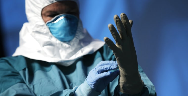 A registered nurse in New York, demonstrates putting on personal protective equipment (PPE) during an Ebola educational session for healthcare workers in New York, Oct. 21, 2014. (Photo by Mike Segar/Reuters)