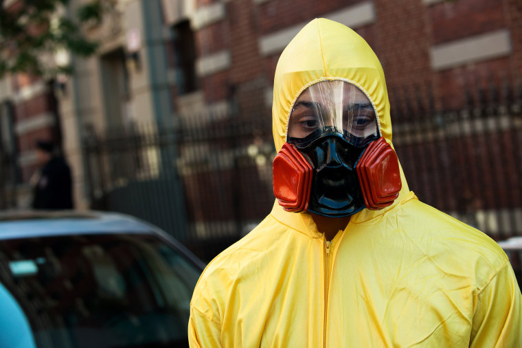 A young man, dressed in a biohazard costume, stands on the corner of 546 West 147th Street on October 25, 2014 in New York City.