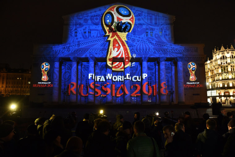 People watch as the facade of the historical Bolshoi Theatre is illuminated with the official emblem of the 2018 FIFA World Cup to be held in Russia in central Moscow on late Oct. 28, 2014. (Photo by Kirill Kudryavtsev/AFP/Getty)