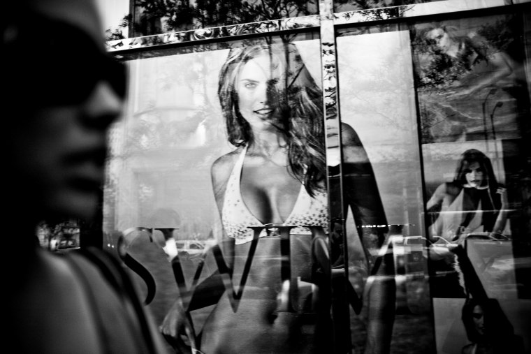 A window reflection of a woman passing by the Victoria's Secret store in Chicago.