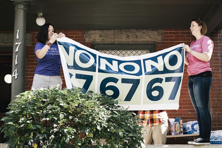 Elena Salisbury, 24, and Kagen Yelmene, 25, hang a sign before a day of canvassing against Amendment 67, which gives fertilized eggs, embryos and fetuses full citizenship rights, in Denver, Co.