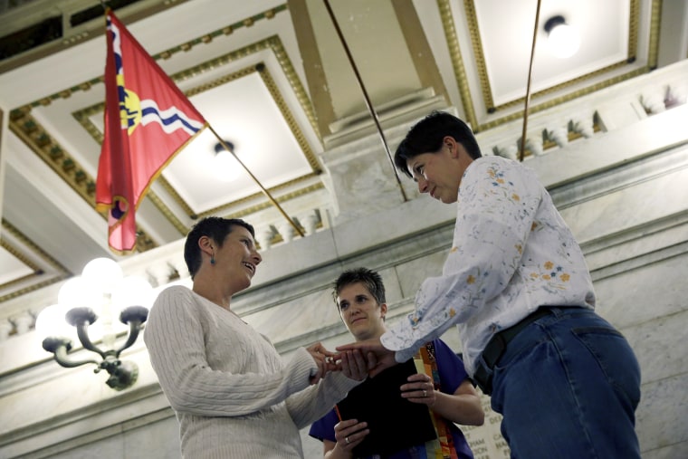 April Dawn Breeden, left, places a ring on the finger of her long-time partner Crystal Peairs, right, as they are married by Rev. Katie Hotze-Wilton on Nov. 5, 2014, at City Hall in St. Louis, Mo.
