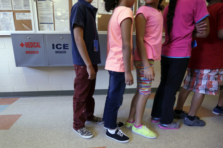 Detained immigrant children line up in the cafeteria at the Karnes County Residential Center, a temporary home for immigrant women and children detained at the border, Sept. 10, 2014, in Karnes City, Texas. (Photo by Eric Gay/AP)