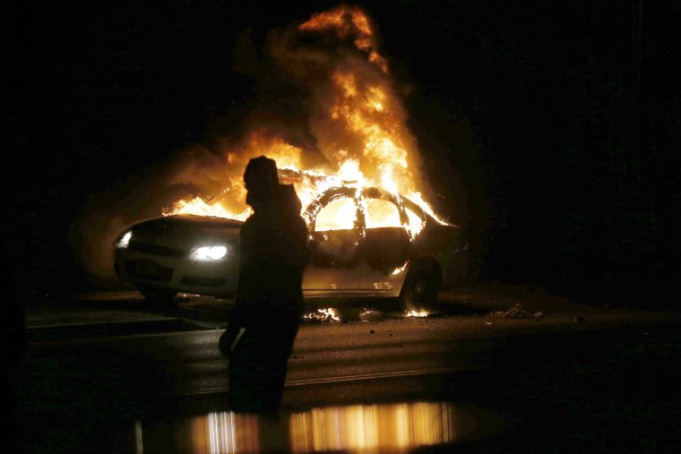 A car burns on the street after a grand jury returned no indictment in the shooting of Michael Brown in Ferguson, Mo. on Nov. 24, 2014. (Photo by Jim Young/Reuters)