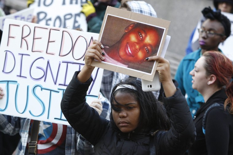 A protester holds a poster picturing shooting victim Tamir Rice, during a rally at Public Square in Cleveland, Ohio on Nov. 24, 2014.