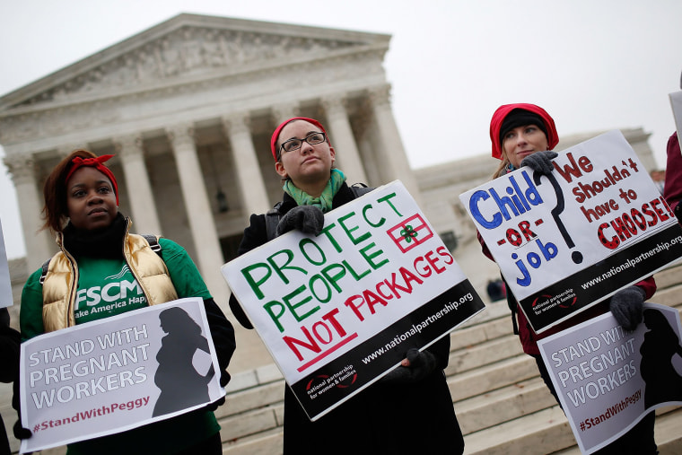 Protesters gather outside the U.S. Supreme Court while the court hears arguments in the Young vs. UPS case on Dec. 3, 2014 in Washington, DC.