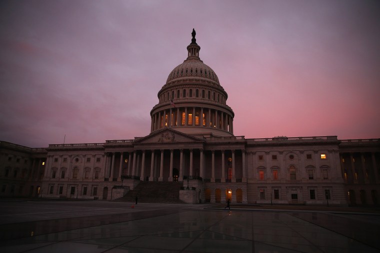 The morning sun begins to rise in front of the U.S. Capitol. (Photo by Mark Wilson/Getty)