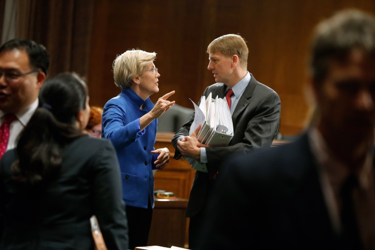 U.S. Senator Warren talks with U.S. Consumer Financial Protection Bureau Director Cordray after he testified about Wall Street reform before a Senate Banking Committee hearing on Capitol Hill in Washington
