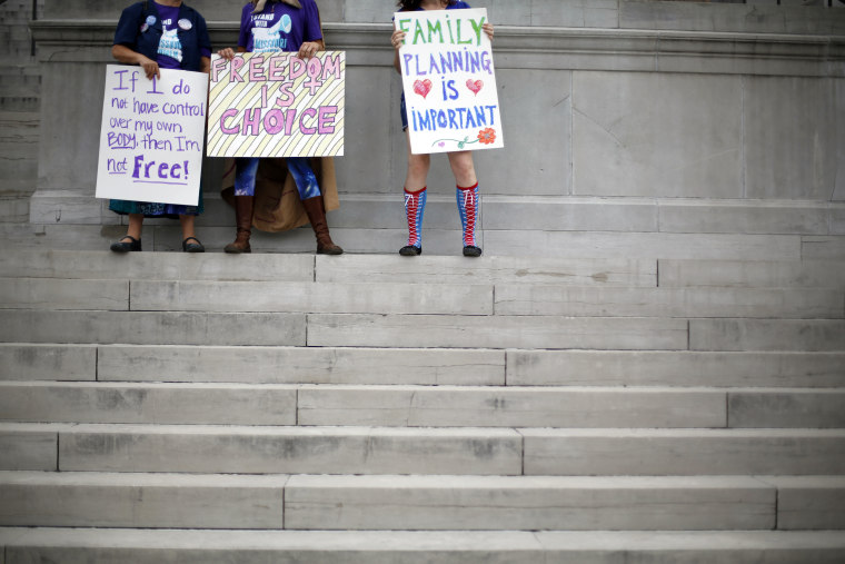 Abortion rights activists hold signs as they stand on the steps of the Missouri Capitol on Sept. 10, 2014, in Jefferson City, Mo. (Jeff Roberson/AP)