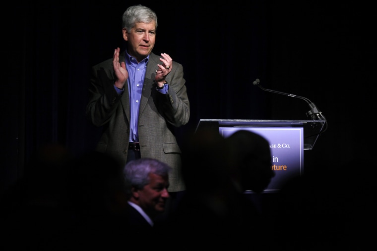 Michigan Governor Rick Snyder applauds during a luncheon May 21, 2014 in Detroit, Michigan. (Photo by Joshua Lott/Getty)