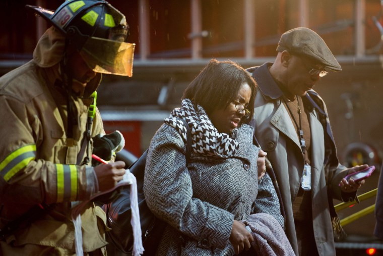 Smoke inhalation victims walk past a firefighter towards a medical aid bus after passengers on the Metro were injured when smoke filled the L'Enfant Plaza station during the evening rush hour Jan. 12, 2015 in Washington, D.C. (Paul J. Richards/AFP/Getty)