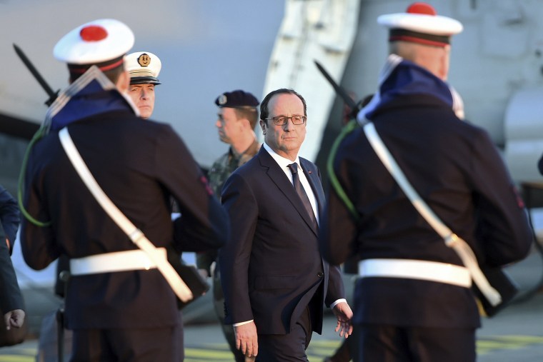 French President Francois Hollande reviews troops during his visit aboard the a French nuclear aircraft carrier on Jan. 14, 2015 off the coast of Toulon, southern France.