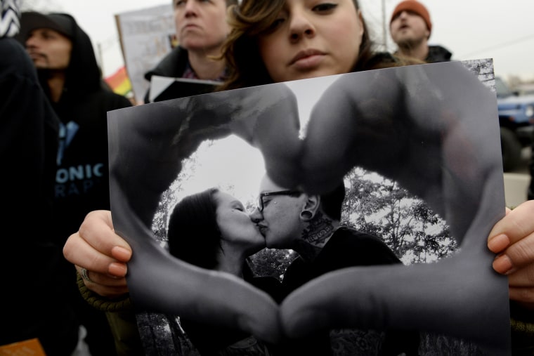 Victoria Quintana carries a photograph of Vanessa Collier, right, and her partner, Christina Higley, during a rally outside New Hope Ministries in Lakewood, Colo. on Jan. 13, 2015. (Photo by Craig F. Walker/The Denver Post/Getty)