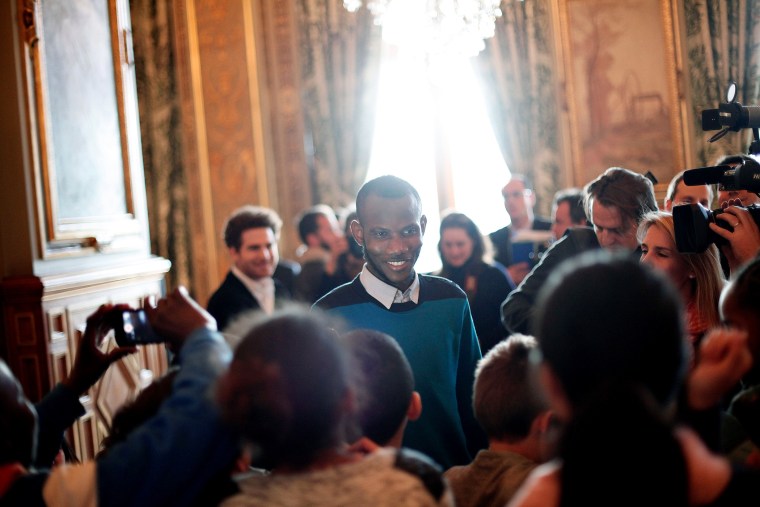 Lassana Bathily, center, talks with children prior to speeches from U.S. Secretary of State John Kerry and Paris' mayor Anne Hidalgo, at the Paris' city hall, on Jan. 16, 2015. (Photo by Thibault Camus/AP)