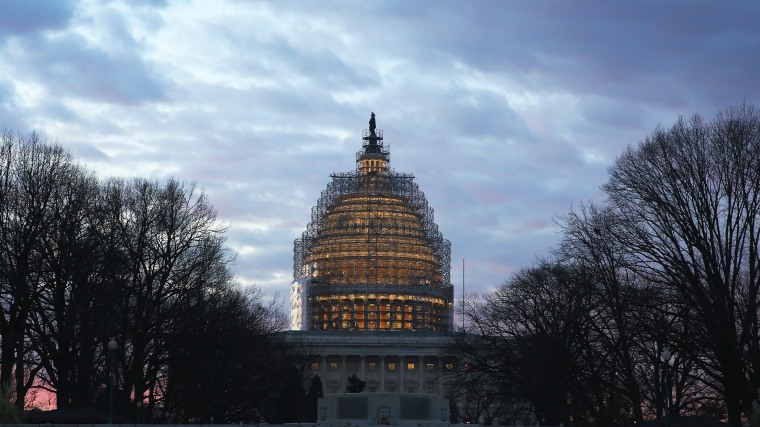 The early morning sun begins to rise behind the US Capitol building on Jan. 20, 2015 in Washington, D.C. (Photo by Mark Wilson/Getty)